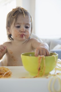 Girl (2-3) eating spaghetti