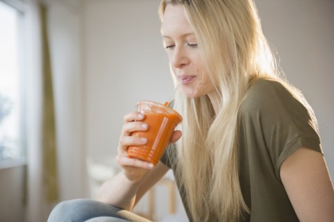 Woman drinking carrot juice