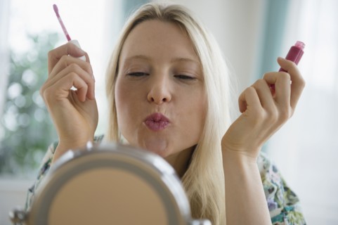 Woman applying lipgloss