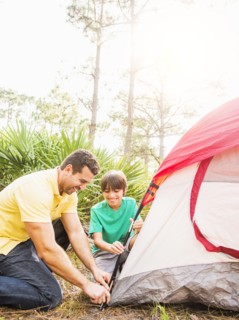 Father and son (12-13) setting up tent