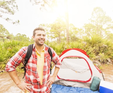 Man with backpack in front of tent
