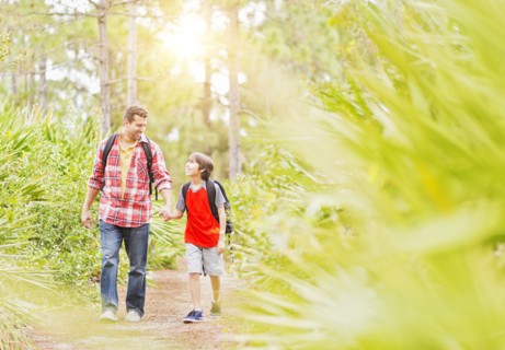Father and son (12-13) walking in forest