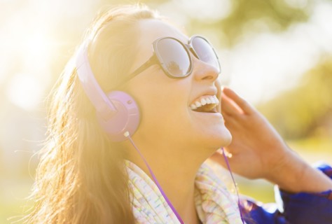 Woman in sunglasses and headphones outdoors