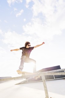 Man jumping on skateboard in skatepark