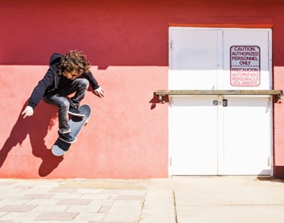 Man skating near red wall