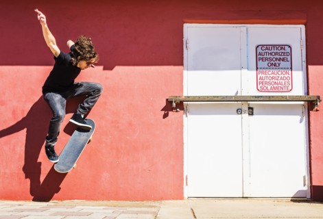 Man skating near red wall