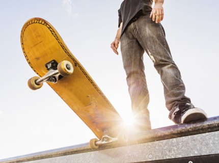 Man with skateboard at the edge of ramp