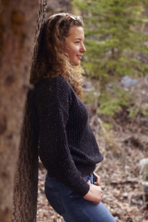 Portrait of young woman leaning on tree