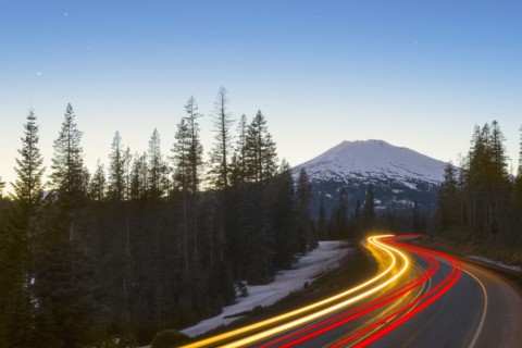 View of light trail on road in forest