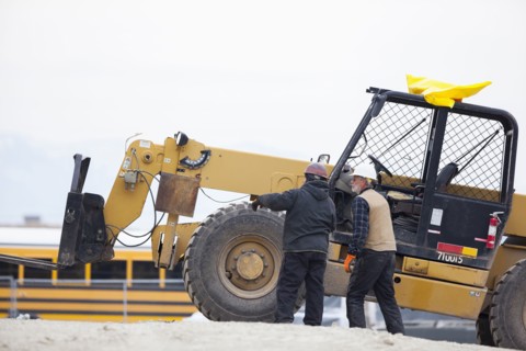Two men standing next to earthmover