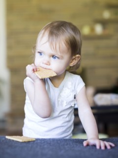 Girl (12-17 months) eating water cracker
