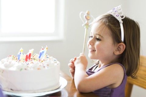 Girl (4-5) looking at birthday cake