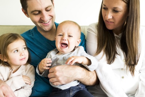 Family with two children (2-3, 4-5) sitting on sofa