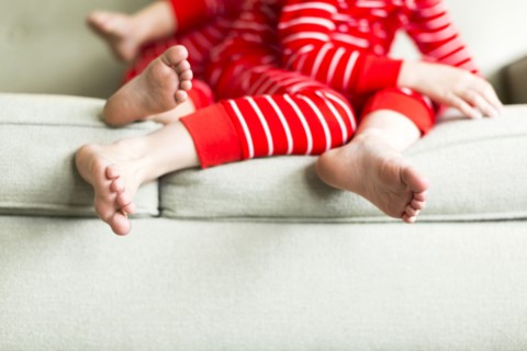 Feet of siblings (2-3, 4-5) in red pajamas