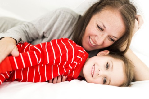 Mom and daughter (2-3) lying in bed