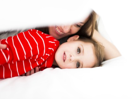 Mom and daughter (2-3) lying in bed