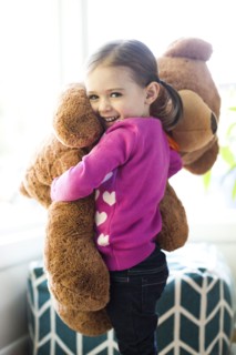 Portrait of girl (4-5) hugging teddy bear