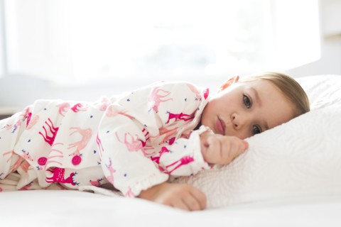 Girl (2-3) lying on bed