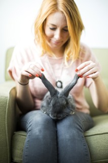 Woman touching rabbit's ears