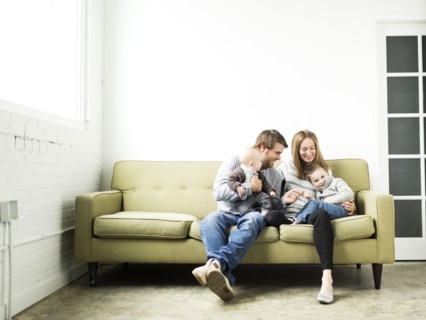 Family embracing on sofa