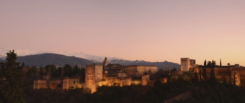 Cityscape with illuminated castle at dusk, pink sky