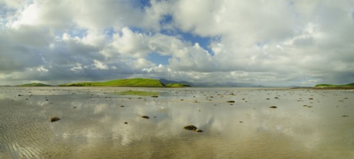 Panoramic landscape with water, clouds and hill on horizon