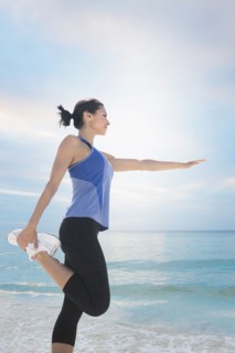 Young woman exercising by sea.
