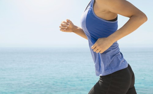Young woman exercising by sea.