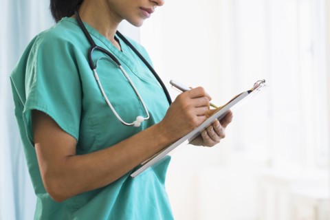 Female doctor making notes.