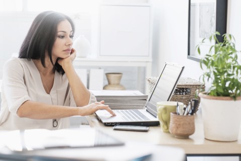 Woman sitting at desk with laptop.
