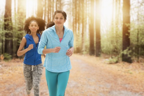 Portrait of teenage girls (14-15, 16-17) running.