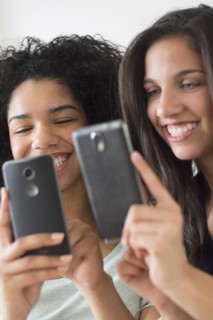 Teenage girls (14-15, 16-17) using smart phones.