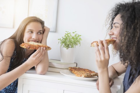 Teenage girls (14-15, 16-17) eating pizza.