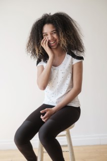 Portrait of teenage girl (16-17) sitting on stool.