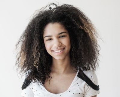 Portrait of teenage girl (16-17) on white background.
