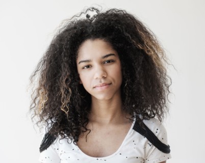 Portrait of teenage girl (16-17) on white background.