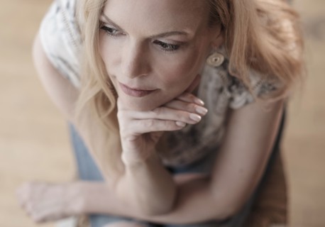 Mid-adult woman sitting on chair, thinking.
