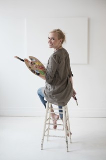 Female artist painting in studio.