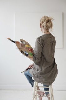 Female artist painting in studio.