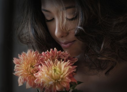 Young woman smelling flowers.