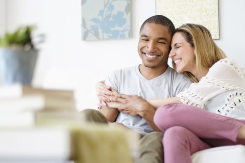 Mid adult couple embracing in living room.