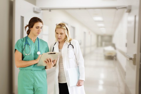 Two female doctors looking at medical documents.