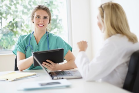 Two female doctors talking in office.