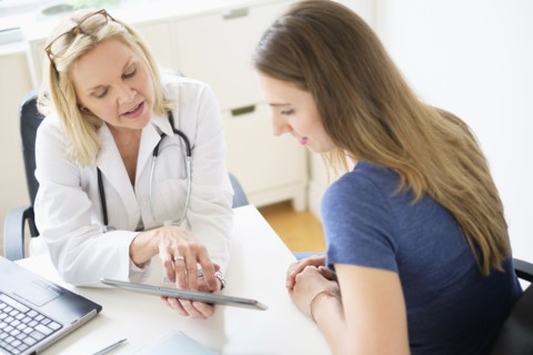 Doctor talking to patient in office.