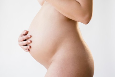 Studio shot of naked, pregnant woman