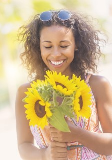 Portrait of smiling woman with sunflowers