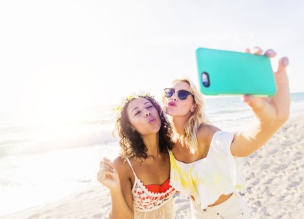 Female friends taking selfie on beach