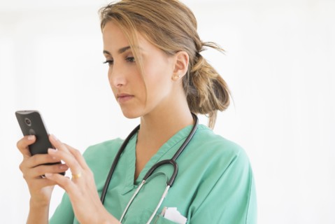 Young female doctor using smart phone.
