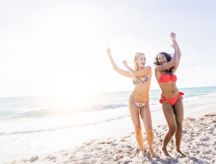 Female friends dancing on beach