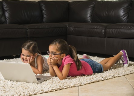 Girls (6-7, 8-9) using laptop at home